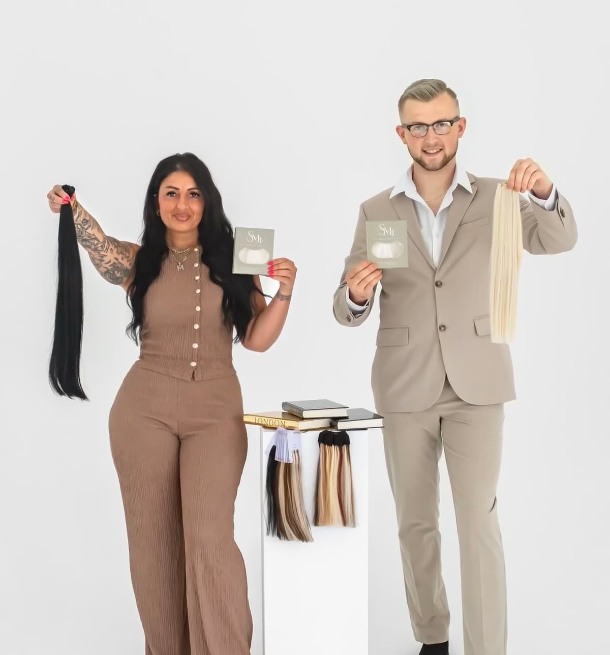 MJ and Storm, co-founders of SMJ Hair Extensions, holding hair-extension bundles in studio